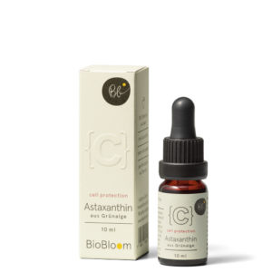 Astaxanthin aus Grünalge in Pipettenflasche mit Verpackung vor schwarzem Hintergrund.