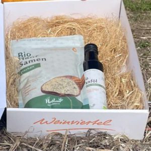 Weinviertler Geschenkbox mit Bio Hanfsamen geschält und Bio Hanföl, im Freien auf Stroh